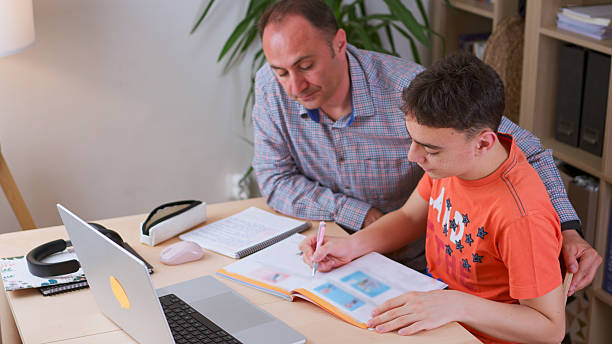 istock Father and teenage boy doing some homework together. 2217873457