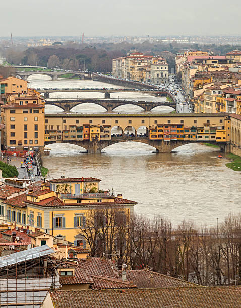 Florence, Tuscany, Italy, August 11, 1992: the Lungarno Generale Diaz shortly after the famous Ponte Vecchio. The Arno river, the Ponte delle Grazie and historic buildings are visible.