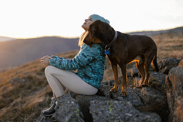 istock Woman with her dog taking a break from hiking 2217877575