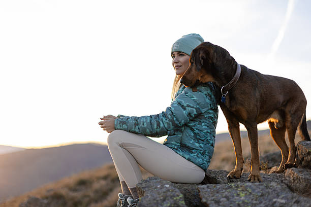 istock Woman with her dog taking a break from hiking 2217877576