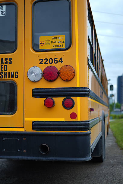 A well-maintained yellow school bus parked in an industrial area. Captured with clear sky and street-level perspective.