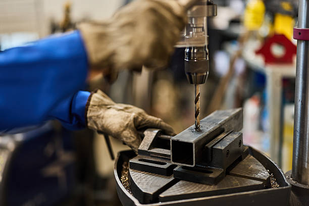 Industrial Worker Drilling Metal with Precision and Professional Tools in Workshop stock photo