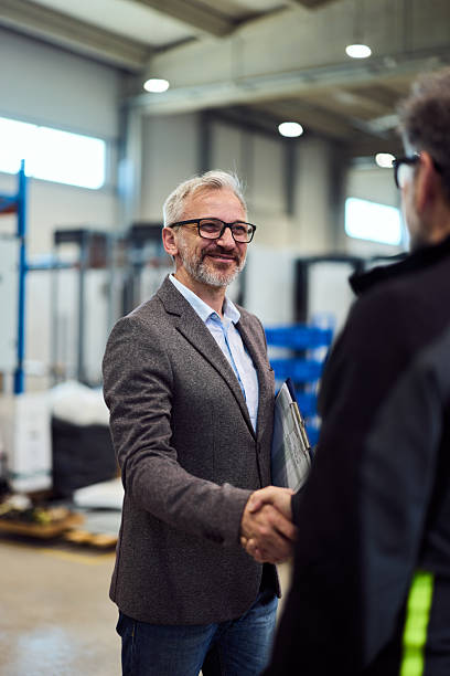 istock Business Professionals Shaking Hands in an Industrial Workspace Environment 2217880855