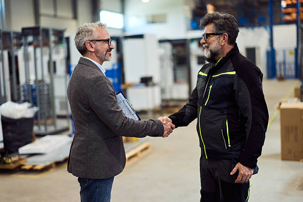 istock Two Professionals Shaking Hands in Modern Factory Environment 2217880860