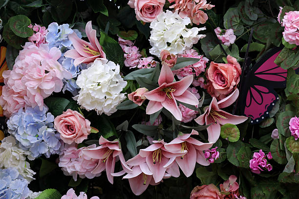 A richly layered floral display featuring a variety of blossoms including roses, lilies, cherry blossoms, and hydrangeas in soft pastel shades of pink, cream, and yellow. Accented with lush green leaves, this arrangement exudes elegance and freshness, ideal for spring-themed design, event decor, or romantic visual concepts.
