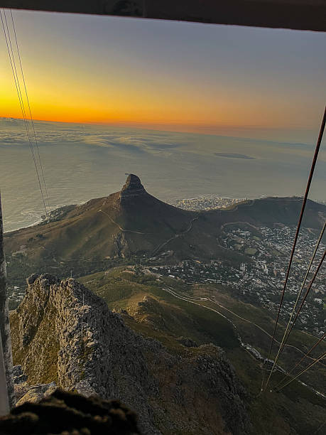 A cable car near the top of Table Mountain with the white sandy beaches of Clifton in the background at Table Mountain National Park, Cape Town in the Western Cape Province of South Africa