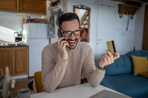 istock Happy man making online payment using credit card and phone 2217887794