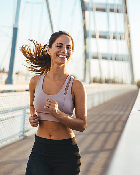 istock Smiling Woman Running on a Bridge During a Sunny Morning 2217888255