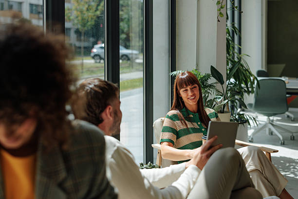 istock Coworkers using tablet and relaxing in modern office lounge area 2217889171
