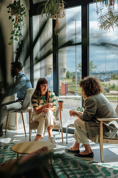 istock Two young women chatting and drinking coffee in a modern cafe 2217889178