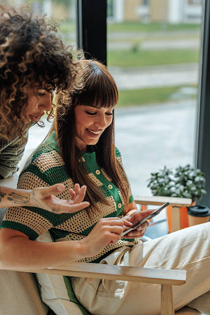 istock Two young businesswomen using a smartphone and smiling in the office 2217889188