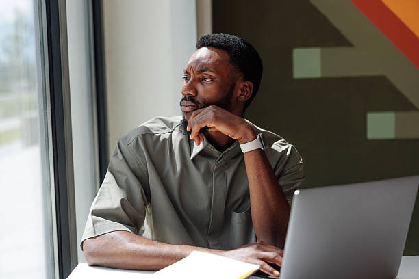 istock Pensive young businessman looking out the window during a work break 2217889190