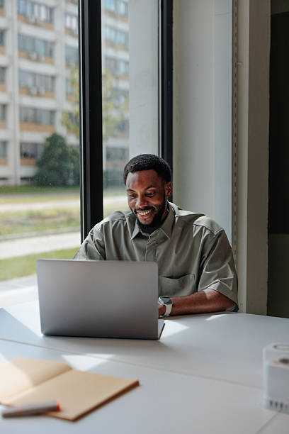 istock Smiling businessman working on laptop in modern office 2217889198