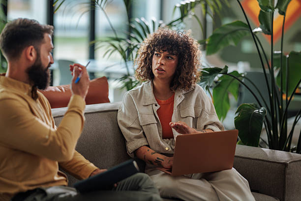 istock Two young colleagues discussing a project using a laptop in a modern office 2217889280