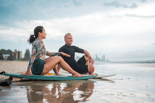 istock Joyful Surfing Couple Relaxing on Gold Coast Beach 2217890178