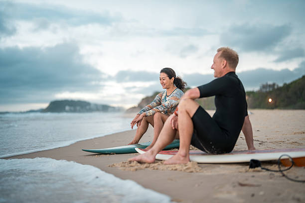 istock Joyful Surfing Couple Relaxing on Gold Coast Beach 2217890180
