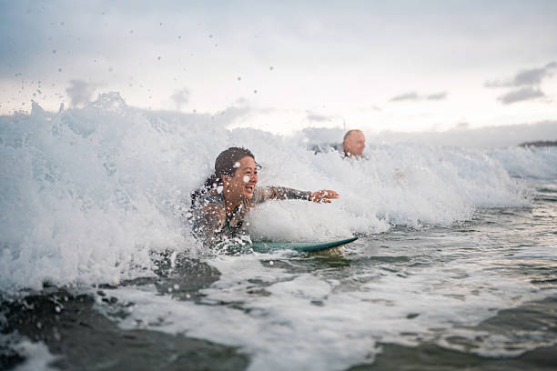 istock Energetic Surfing Couple Riding Waves at Gold Coast Beach 2217890188