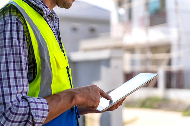 istock Close-up of male engineer's fingers touching on digital tablet screen while working on construction site. 2217894661