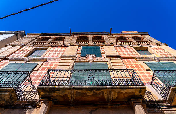 istock Low angle view of a building with balconies and patterned walls against a blue sky. 2217901629