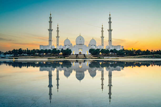 istock Illuminated Sheikh Zayed Grand Mosque with reflections at sunset, Abu Dhabi, UAE. Tourist sightseeing famous grand mosque attraction in United arab emirates. 4k high quality colorful day to night 2217910726