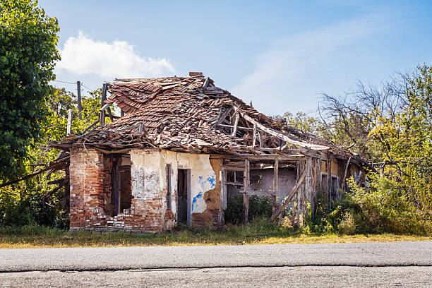 An old, dilapidated house stands deserted in Bulgaria, covered in overgrowth and exposed to the elements.