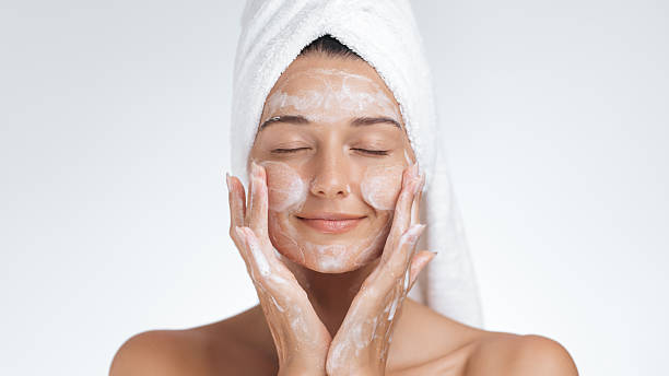 istock Relaxed Woman Massaging Face With Skincare Routine in Soft Towel 2217917366