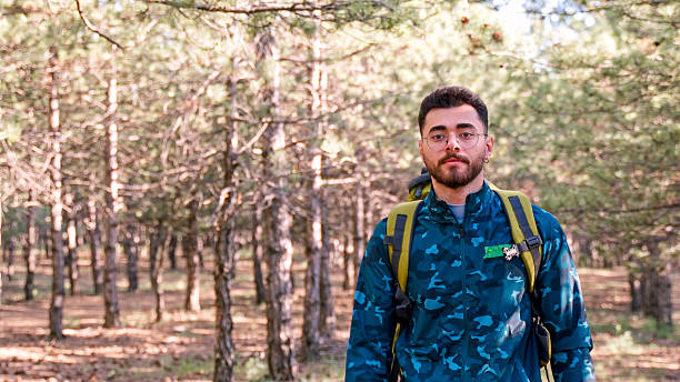 istock Man Hiking Through Pine Forest Trail on a Sunny Day 2217917804