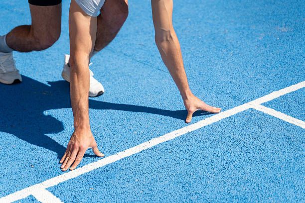 istock Athlete crouching at starting line on track 2217924379
