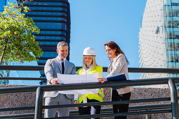 istock Architects discussing blueprints near contemporary urban structures, professional team working together on innovative real estate design project 2217927489
