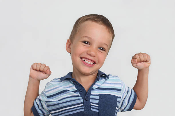istock happy little boy showing strong fists, studio portrait 2217932897