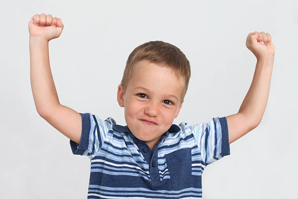 istock happy little boy showing strong fists, studio portrait 2217932920