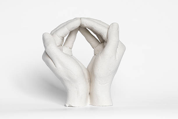 Plaster sculpture of clasped hands on white background , plaster hands stock photo