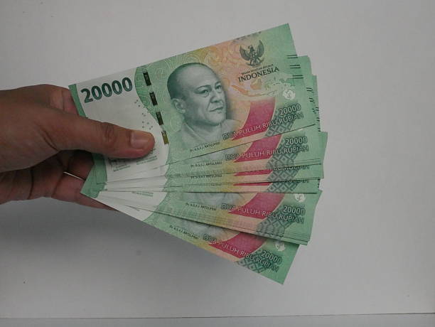 istock hand holding a 20,000 rupiah banknote 2217937004