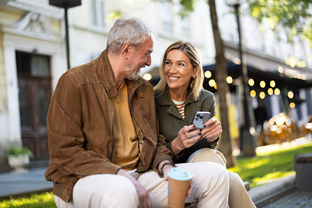 istock Senior couple using smartphone and enjoying coffee outdoors 2217941056