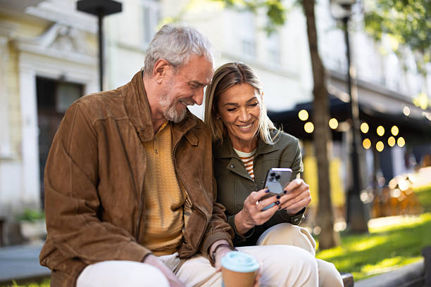 istock Happy senior couple using smartphone outdoors and smiling 2217941061