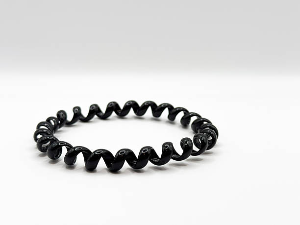 istock Black glossy silicone hair elastic spiral macro shot on white background front view 2217944096