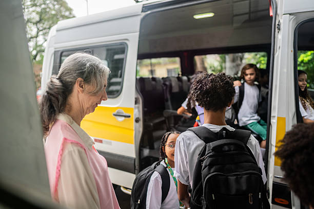 istock Teacher and students entering inside of school van 2217945159