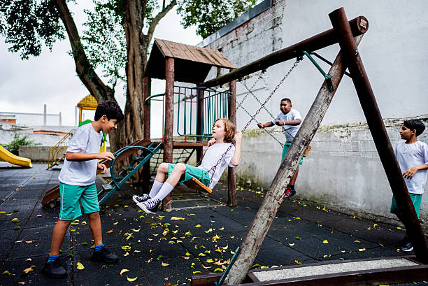 istock Schoolboys playing on swing at schoolyard 2217945749