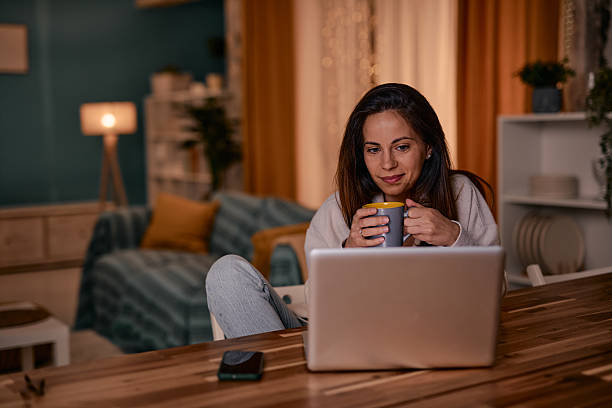 istock Woman enjoying a cup of coffee while working from home on her laptop 2217946521