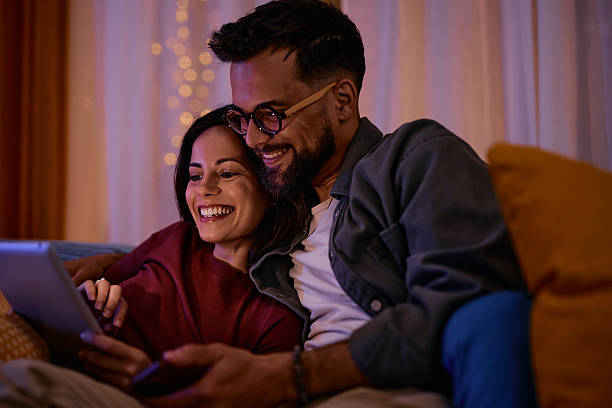 istock Happy couple using digital tablet, relaxing on sofa at home 2217946683