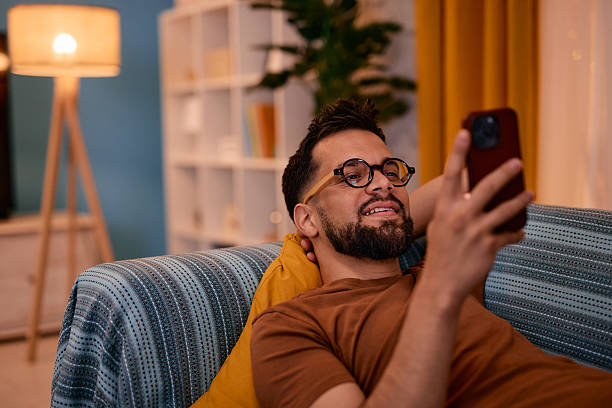 istock Young man relaxing on the sofa using his smartphone 2217946695