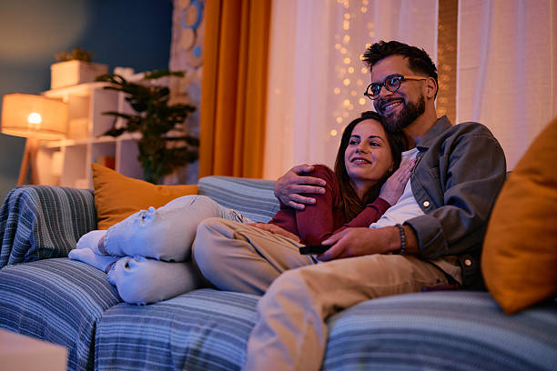 istock Young couple watching television embraced on the sofa at night 2217946809
