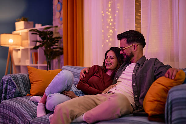 istock Young couple relaxing on sofa, enjoying romantic evening at home 2217946810