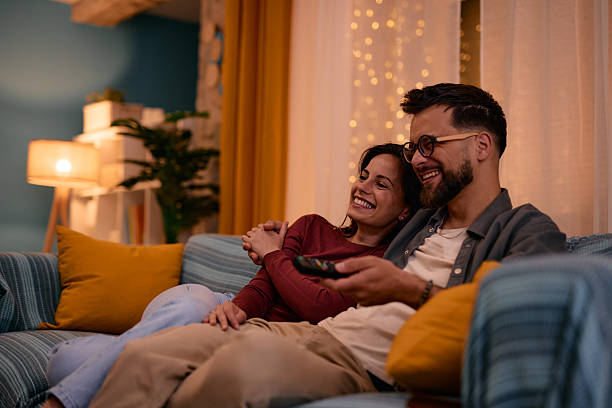 istock Couple relaxing on sofa watching television at night 2217946853