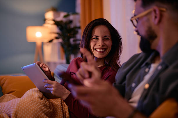 istock Couple relaxing on the sofa using digital tablet and smartphone at night 2217946856