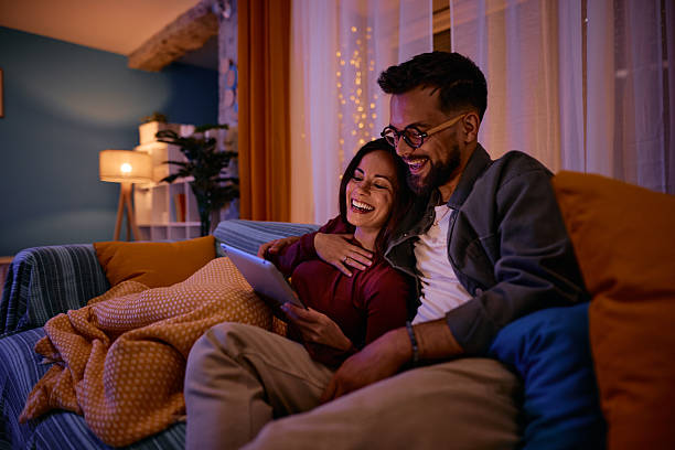 istock Happy couple laughing and using digital tablet at home 2217946870