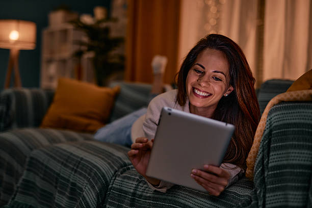 istock Young woman relaxing on the sofa, using digital tablet and smiling 2217946924
