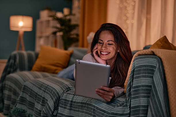istock Young woman relaxing on the sofa using digital tablet at night 2217946960