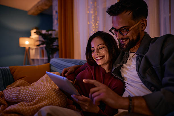 istock Couple relaxing on the sofa using a digital tablet at night 2217947096