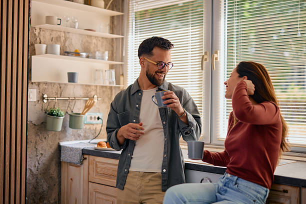 istock Young couple drinking coffee and having fun in the kitchen 2217947101